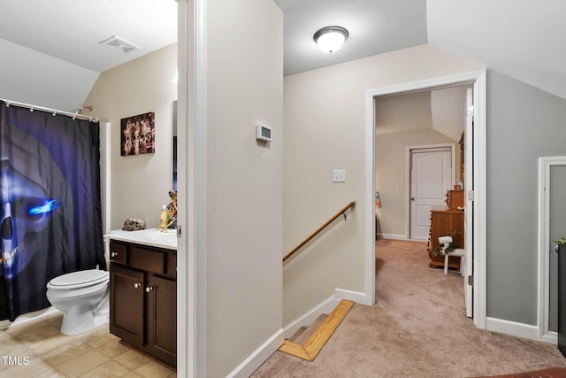 interior space featuring vanity, lofted ceiling, toilet, and visible vents