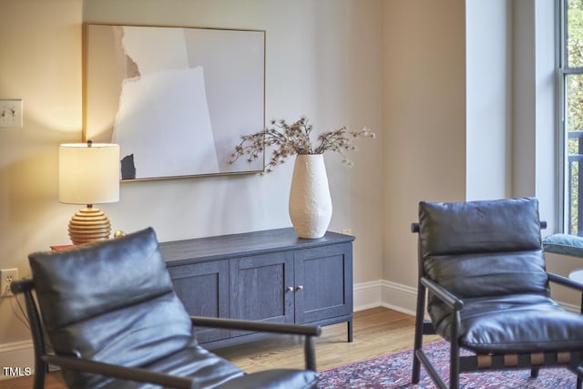 living area featuring baseboards and wood finished floors