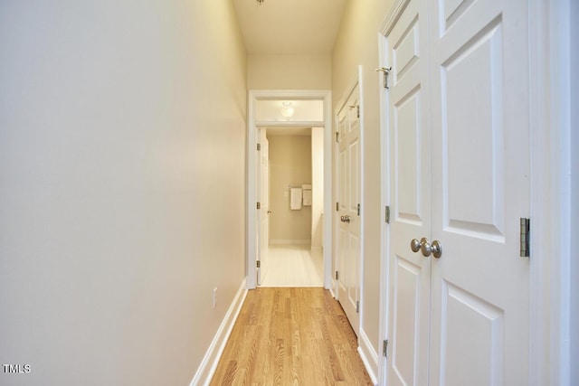 hall featuring baseboards and light wood-style floors