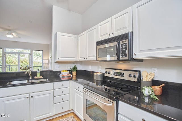 kitchen featuring electric stove, white cabinets, a sink, and ceiling fan