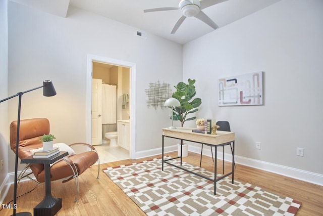 home office with visible vents, light wood-type flooring, a ceiling fan, and baseboards