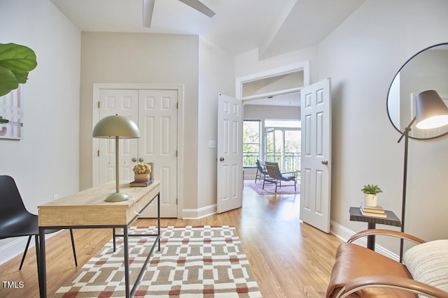 office with light wood-type flooring, baseboards, and a ceiling fan