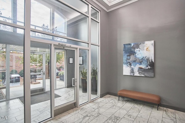 entryway featuring marble finish floor, baseboards, a high ceiling, and ornamental molding