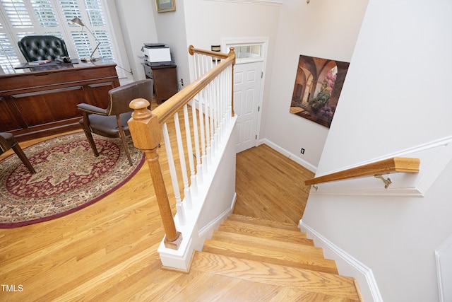 staircase with baseboards and wood finished floors