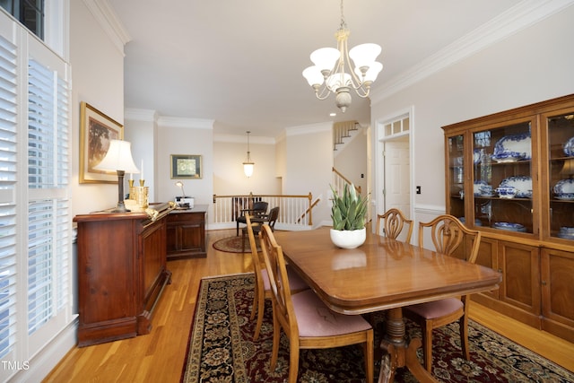 dining space featuring light wood finished floors, ornamental molding, and a wealth of natural light