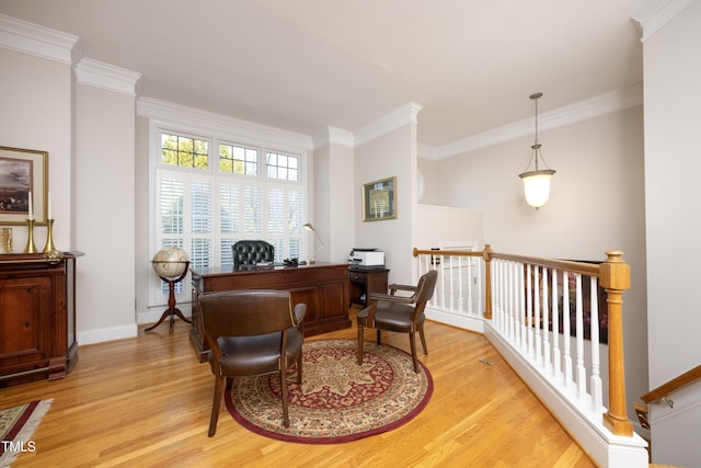 office space featuring baseboards, light wood-type flooring, and crown molding