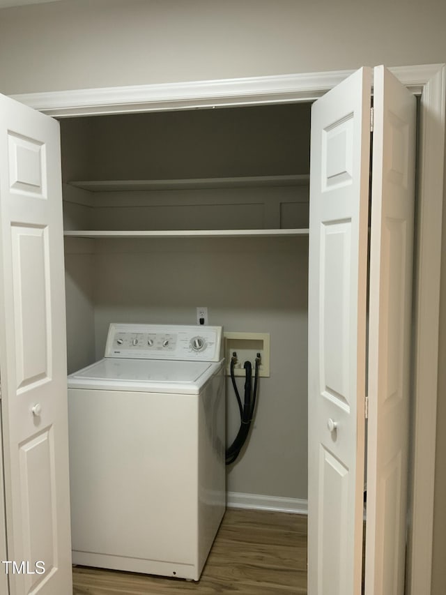 washroom featuring baseboards, washer / dryer, and wood finished floors