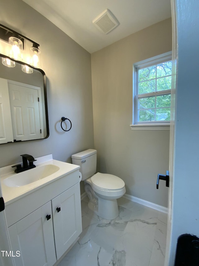 bathroom featuring visible vents, vanity, baseboards, toilet, and marble finish floor