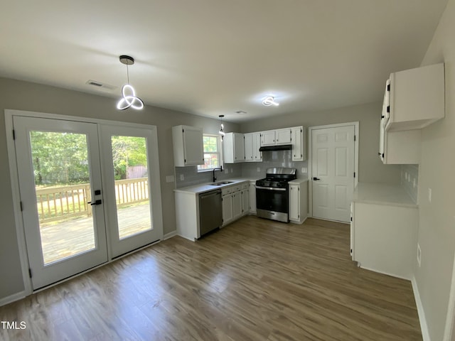 kitchen with a sink, french doors, stainless steel appliances, wood finished floors, and visible vents