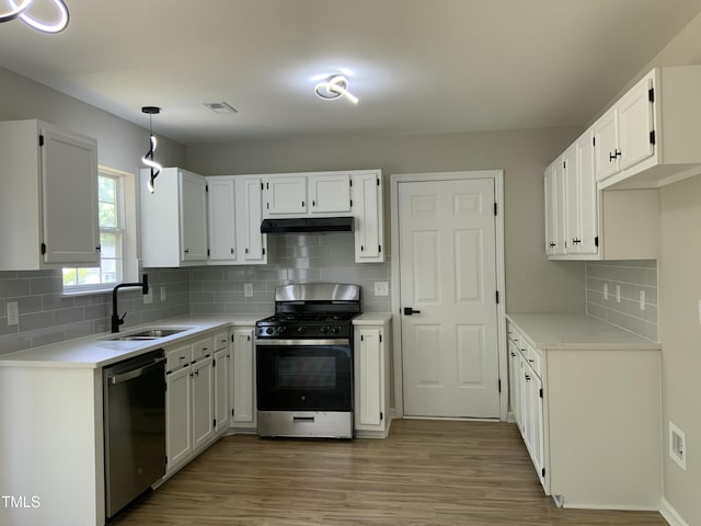 kitchen with range with gas stovetop, under cabinet range hood, a sink, light wood-style flooring, and dishwasher