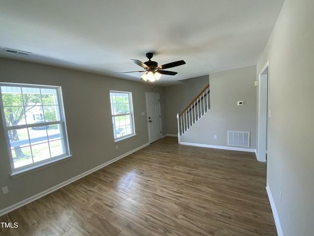 interior space featuring baseboards, ceiling fan, stairs, and visible vents