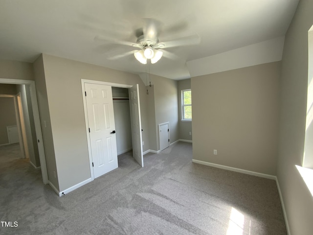 unfurnished bedroom with baseboards, ceiling fan, carpet, and a closet