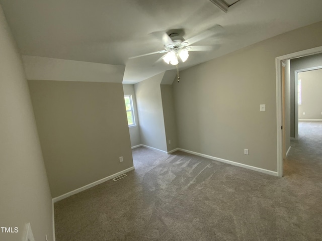 empty room featuring carpet flooring, a ceiling fan, baseboards, and visible vents