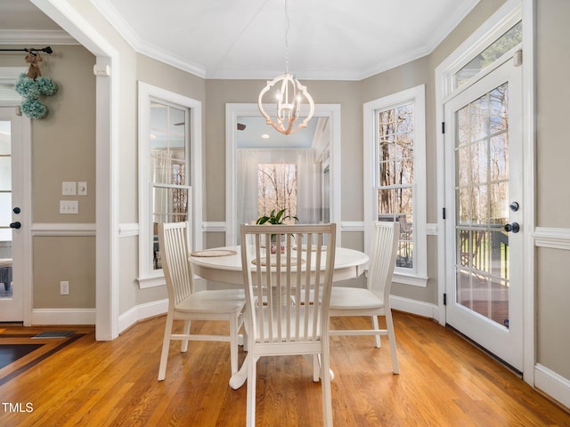 dining room with a notable chandelier, light wood-style flooring, and ornamental molding