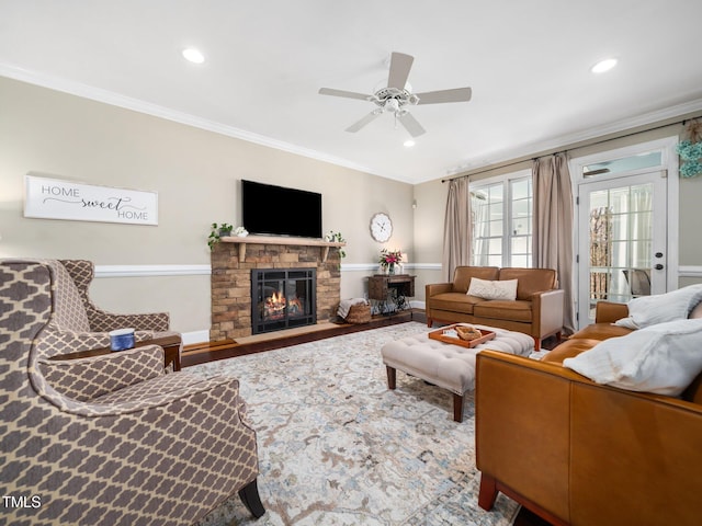 living room featuring crown molding, wood finished floors, a fireplace, and recessed lighting