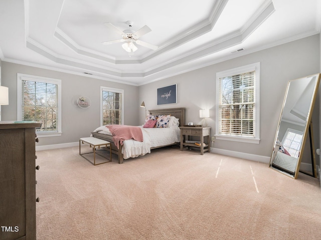 carpeted bedroom with a raised ceiling, baseboards, and ornamental molding