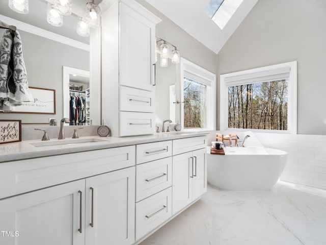 bathroom featuring a soaking tub, double vanity, marble finish floor, and a sink