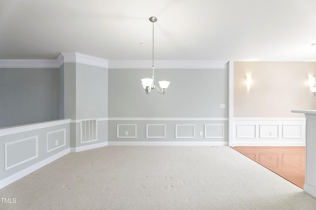 carpeted spare room featuring crown molding, a decorative wall, visible vents, and a notable chandelier