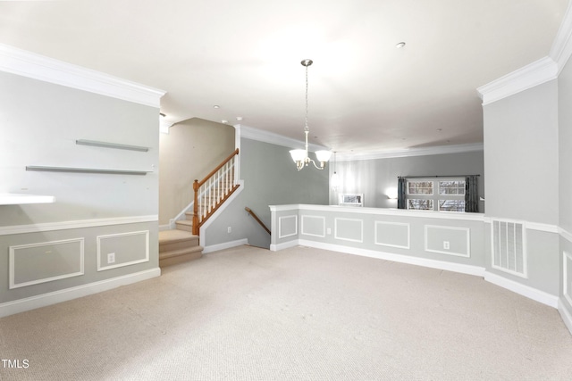 carpeted spare room with a notable chandelier, a decorative wall, visible vents, stairs, and crown molding