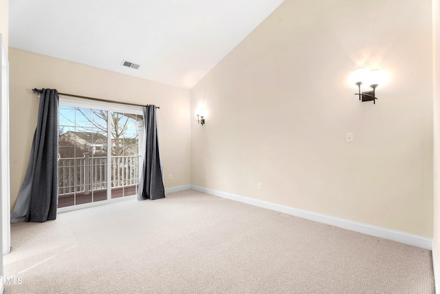 spare room with carpet floors, visible vents, vaulted ceiling, and baseboards