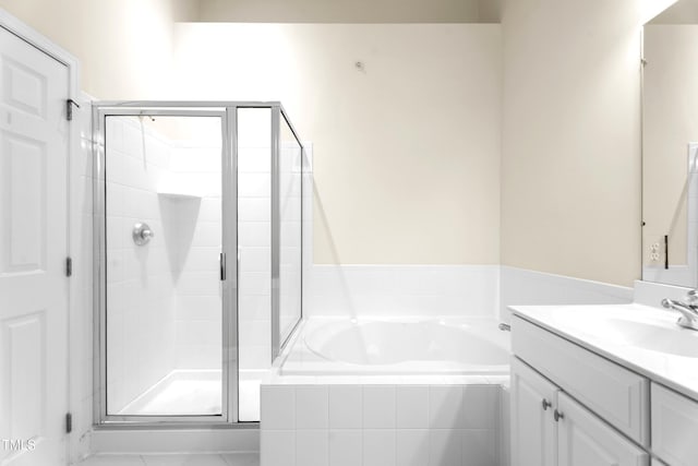 bathroom with a stall shower, vanity, and a bath