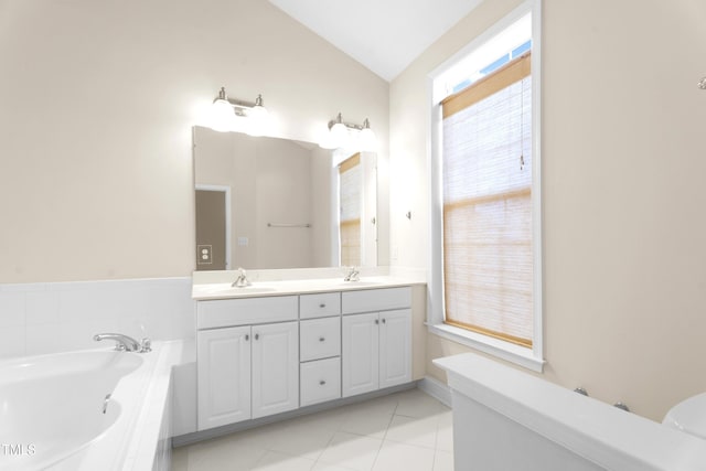 full bathroom with vaulted ceiling, double vanity, a sink, and a bath