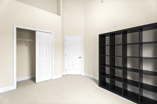 unfurnished bedroom featuring carpet floors, baseboards, and a closet