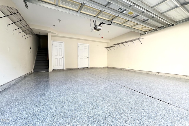 garage with baseboards and a garage door opener