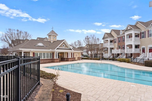 pool with a patio and fence