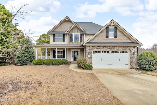 craftsman inspired home with a porch, a garage, concrete driveway, stone siding, and board and batten siding