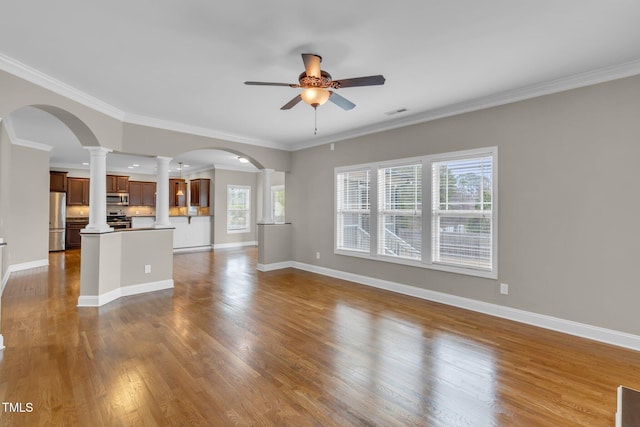 unfurnished living room with decorative columns, baseboards, a ceiling fan, ornamental molding, and dark wood-style flooring