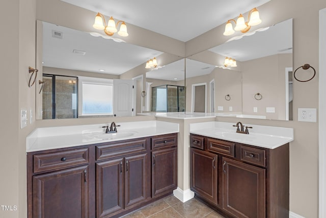 bathroom with tile patterned flooring, a sink, and a shower stall