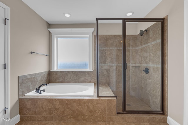 bathroom featuring a stall shower and a garden tub