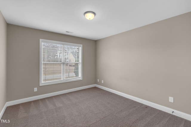 unfurnished room featuring carpet, visible vents, and baseboards