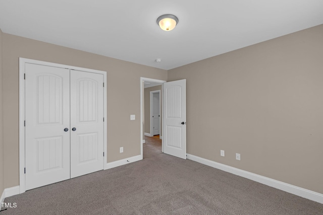 unfurnished bedroom featuring a closet, carpet flooring, and baseboards