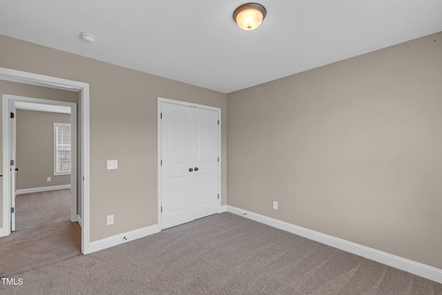 unfurnished bedroom featuring carpet, a closet, and baseboards