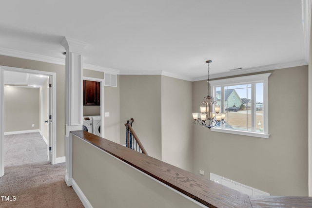 hallway featuring carpet, visible vents, an upstairs landing, a chandelier, and washer and dryer