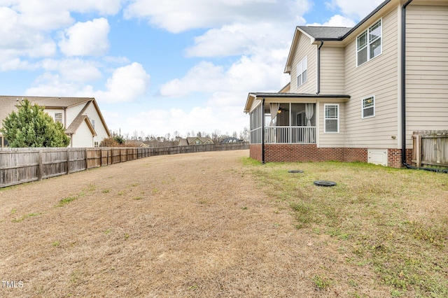 view of yard featuring a fenced backyard and a sunroom