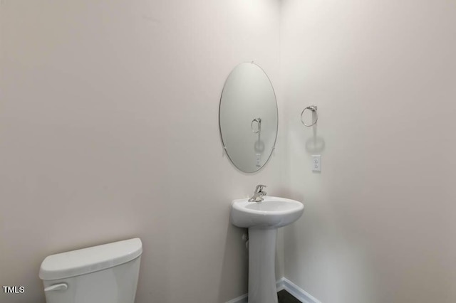 bathroom with toilet and baseboards