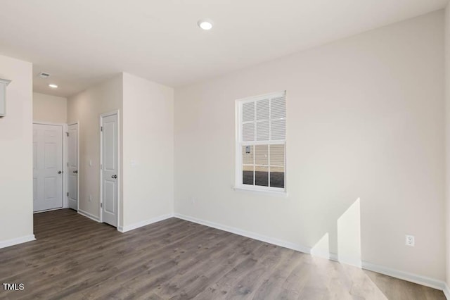 empty room featuring baseboards, wood finished floors, and recessed lighting