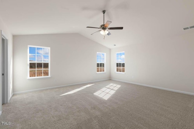 spare room with ceiling fan, visible vents, baseboards, vaulted ceiling, and carpet