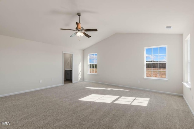 unfurnished bedroom featuring lofted ceiling, ceiling fan, ensuite bathroom, baseboards, and carpet