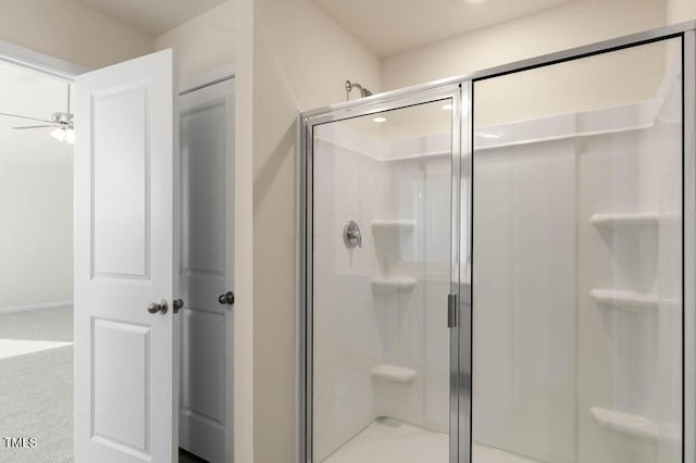 bathroom with a stall shower and a ceiling fan