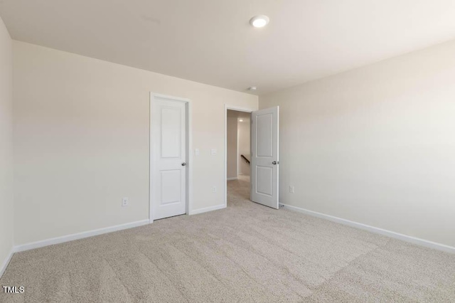 carpeted spare room featuring baseboards