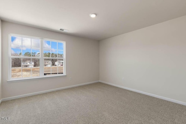 carpeted empty room with visible vents and baseboards