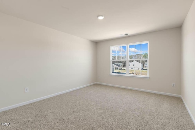 unfurnished room with baseboards, visible vents, and light colored carpet