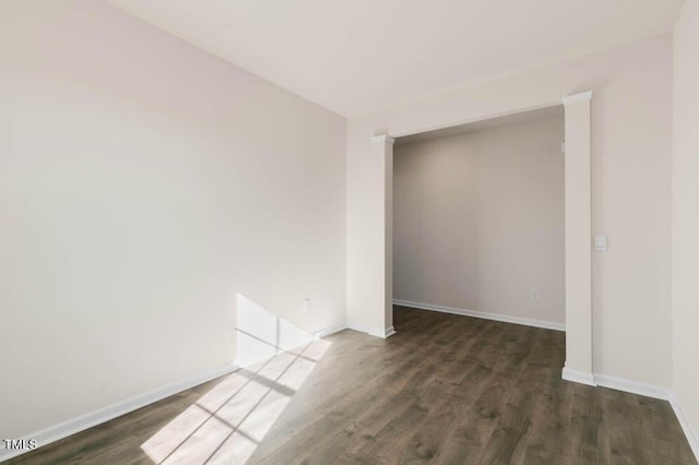 empty room with baseboards and wood finished floors