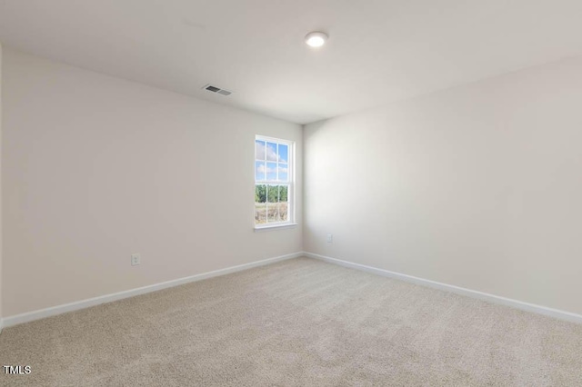 unfurnished room featuring baseboards, visible vents, and light colored carpet