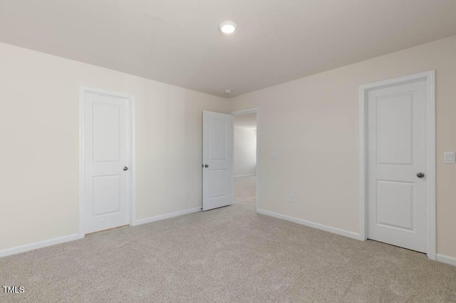 unfurnished bedroom with light carpet and baseboards