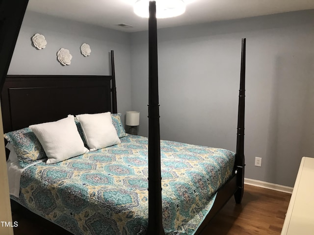 bedroom featuring wood finished floors, visible vents, and baseboards